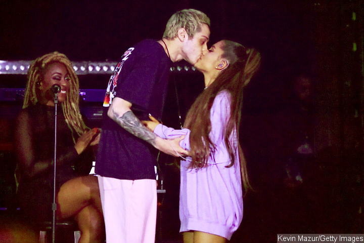 Ariana Grande and Pete Davidson lock lips onstage.