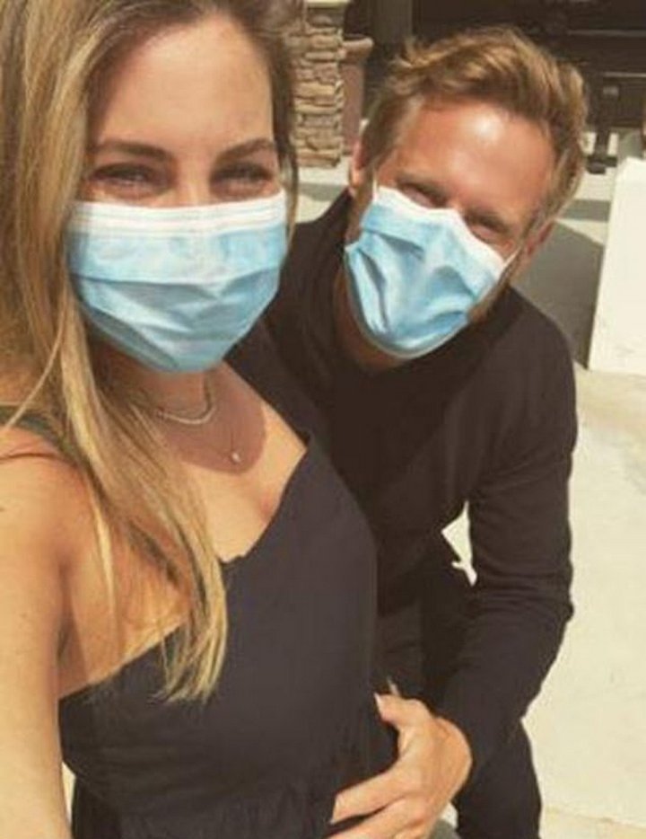 Trevor Engelson cradling his wife's baby bump