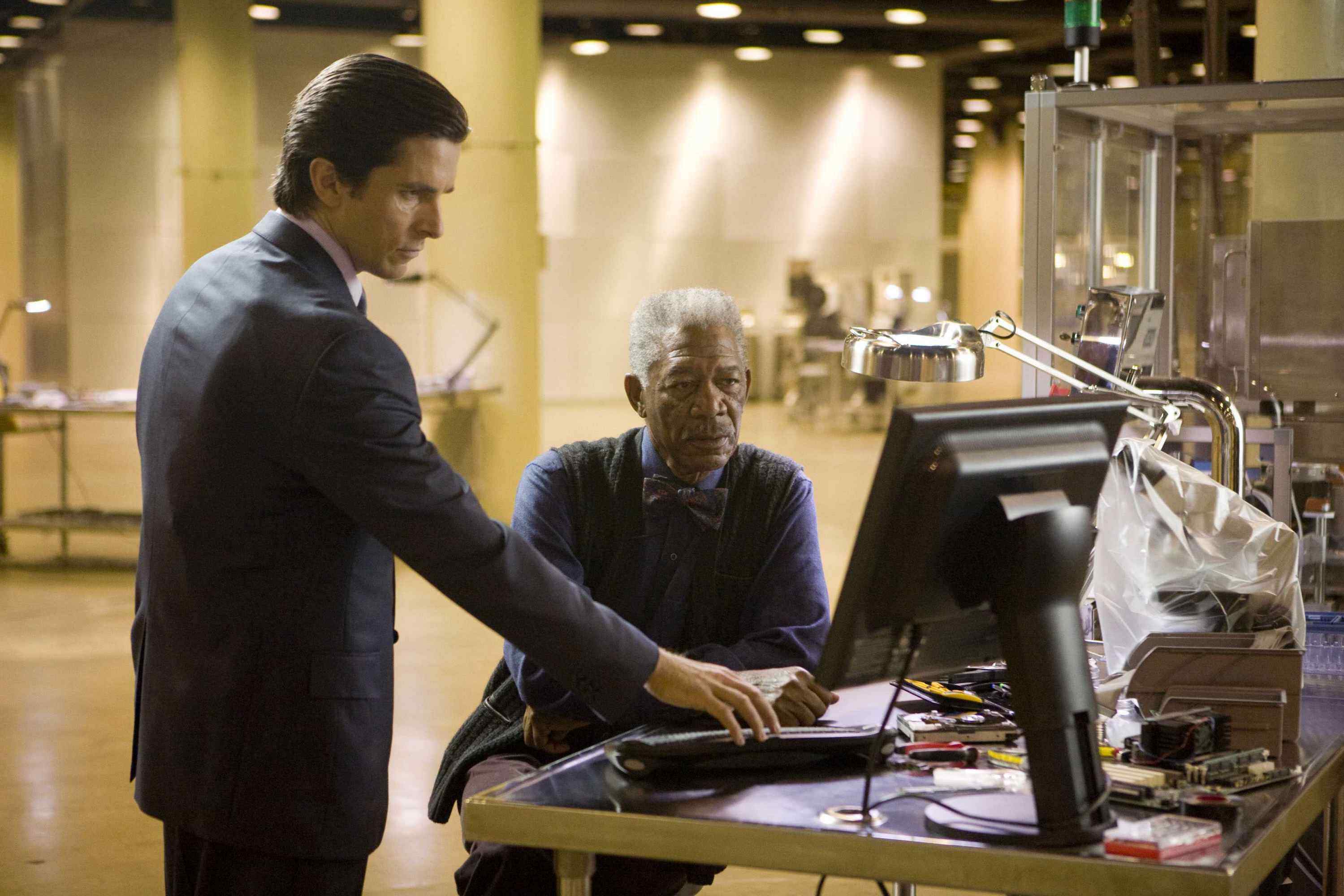 CHRISTIAN BALE stars as Bruce Wayne and MORGAN FREEMAN as Lucius Fox in Warner Bros. Pictures' and Legendary Pictures' action drama 
